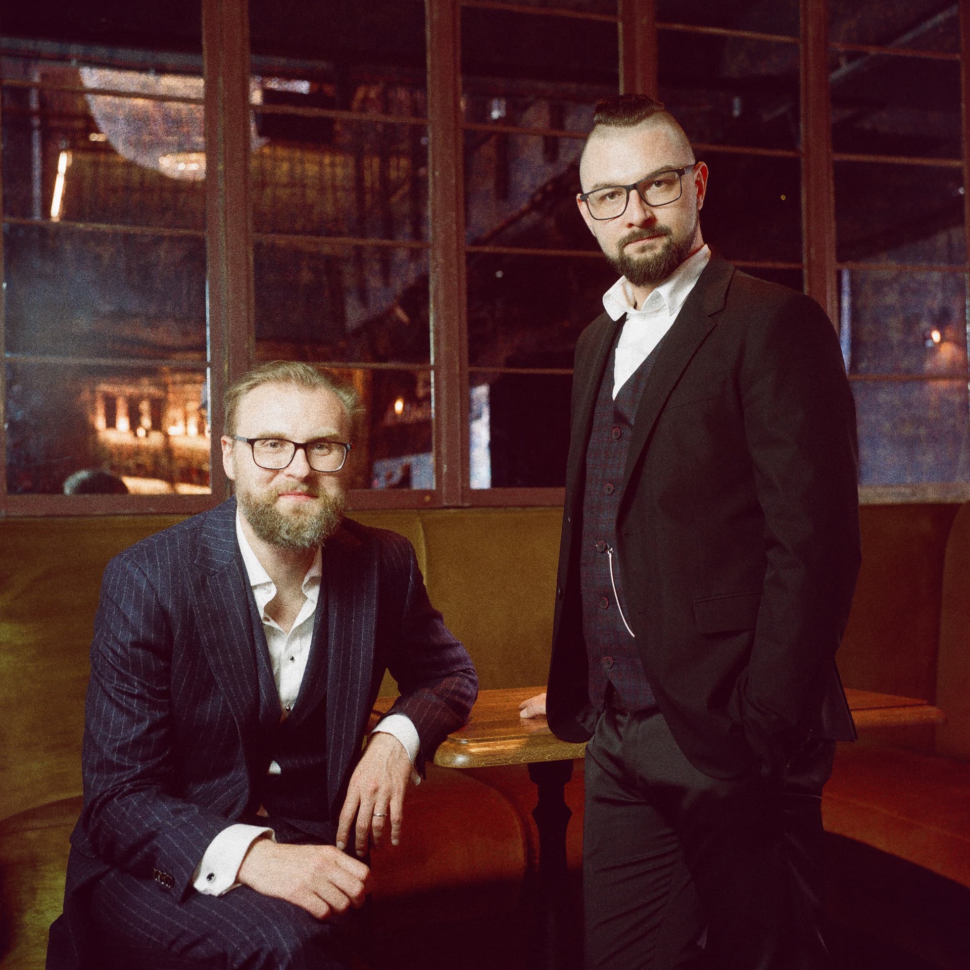 Damian Szymczak i Piotr Tomala, duet Orkiestry Ludwika Sarskiego, w garniturach we wnętrzu klubu